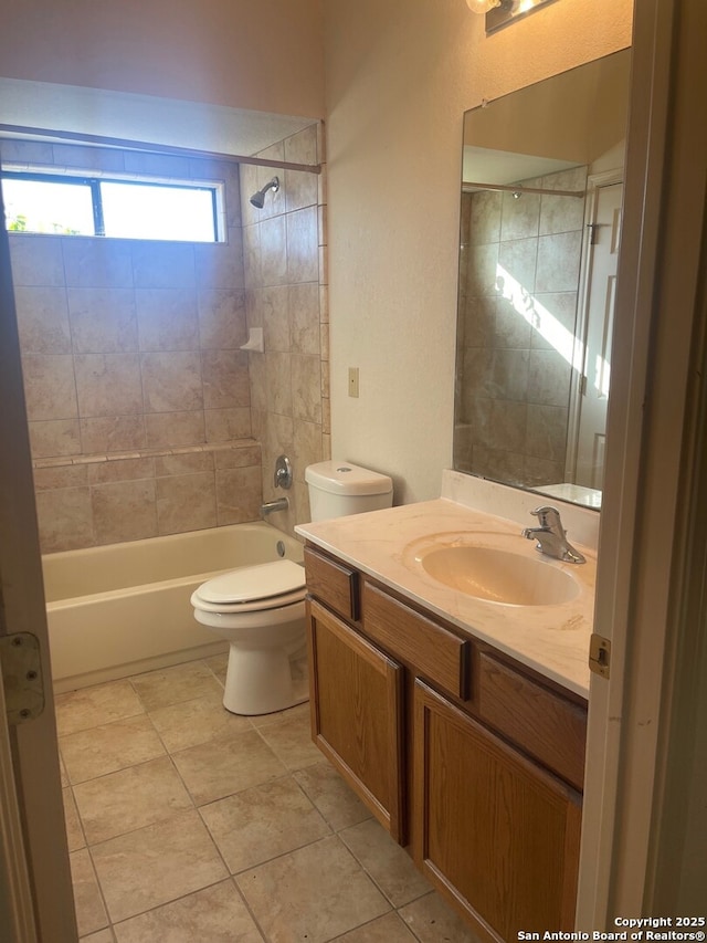 full bathroom featuring toilet, tile patterned flooring, tiled shower / bath combo, and vanity