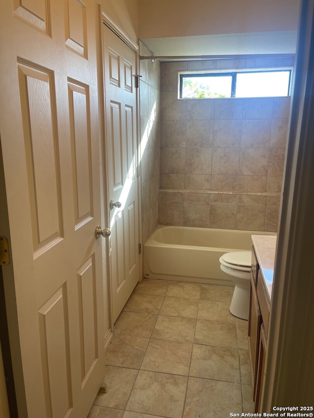 full bathroom featuring tile patterned floors, toilet, vanity, and tiled shower / bath combo