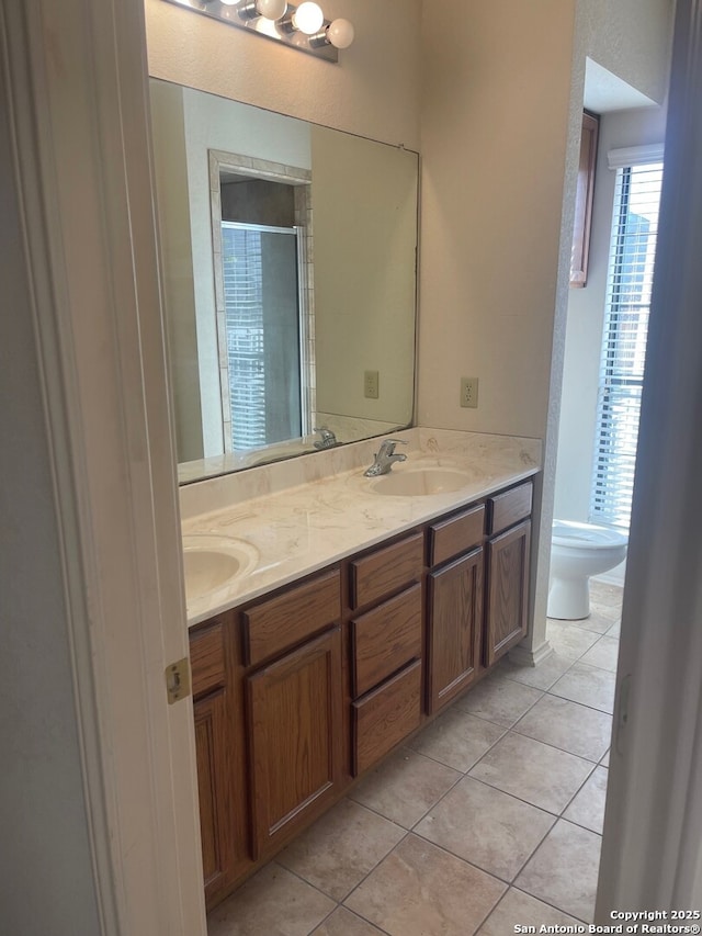 bathroom with toilet, tile patterned flooring, and vanity