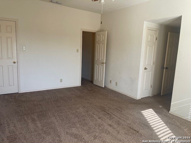 carpeted spare room featuring ceiling fan