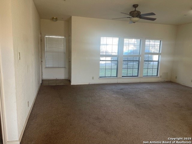 carpeted spare room featuring ceiling fan