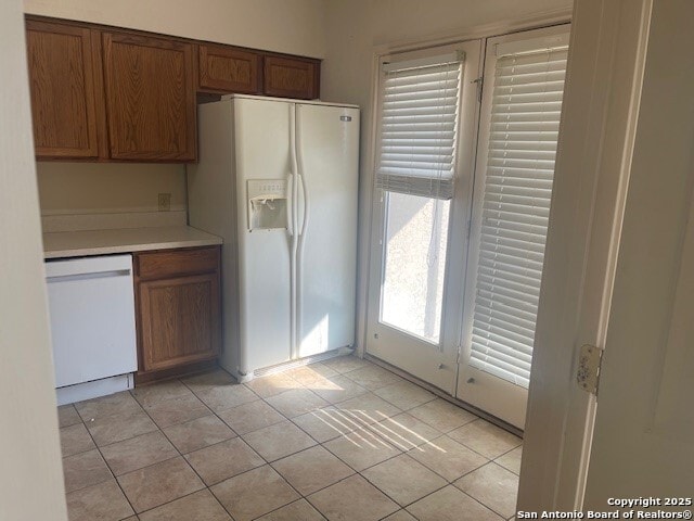 kitchen with light tile patterned floors and white appliances