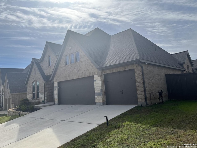 view of property exterior featuring a garage and a lawn