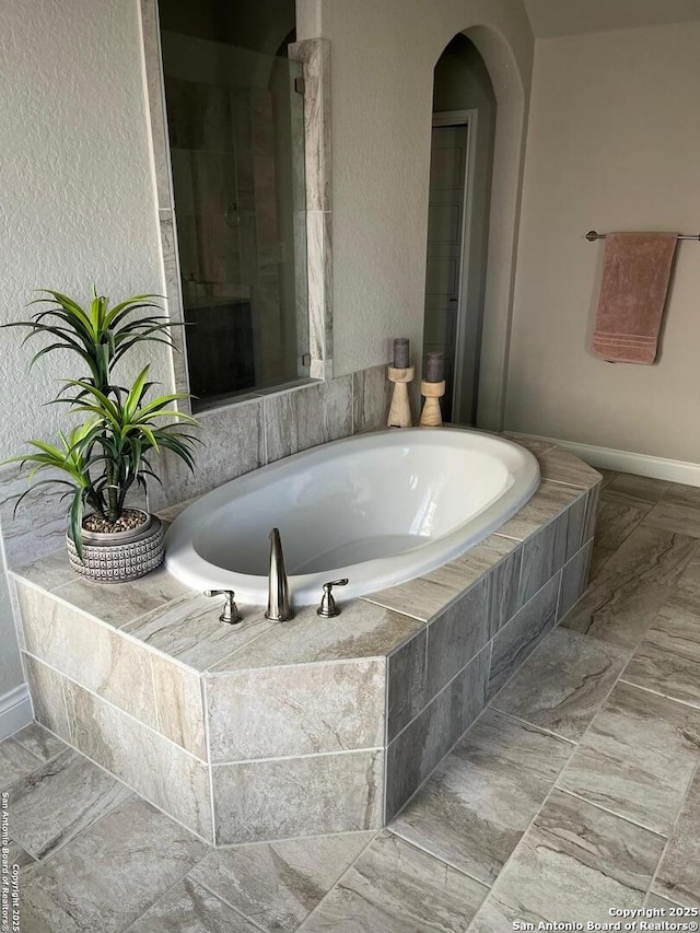 bathroom featuring a relaxing tiled tub