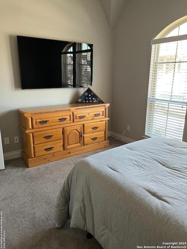 bedroom with vaulted ceiling and carpet flooring