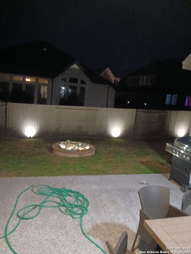 yard at night featuring a patio area