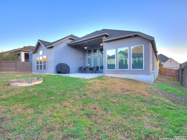 back of house with a patio area and a lawn