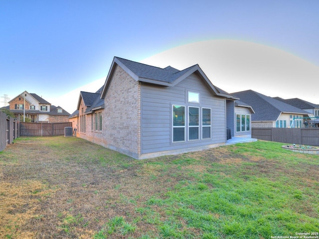 rear view of house with a yard and central AC unit