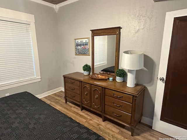 bedroom featuring wood-type flooring and ornamental molding