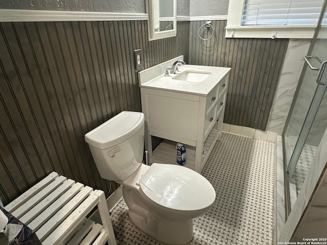 bathroom with toilet, tile patterned flooring, a shower with door, and vanity