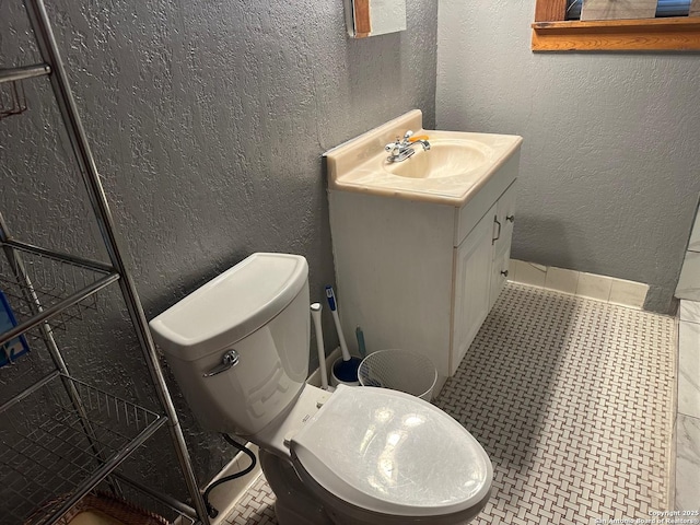 bathroom with toilet, tile patterned flooring, and vanity