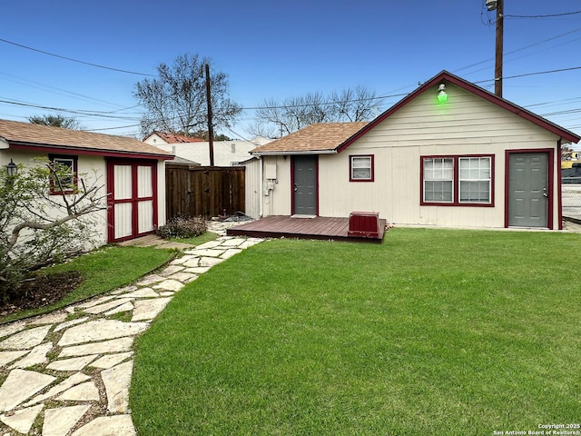 back of property with a shed, a wooden deck, and a yard