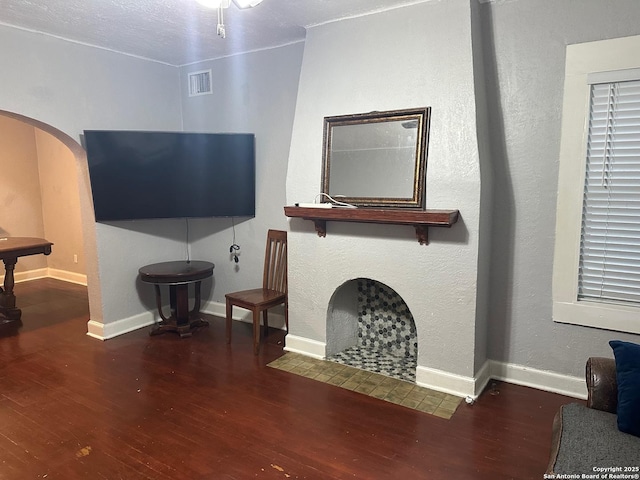 living room with a textured ceiling and dark hardwood / wood-style flooring