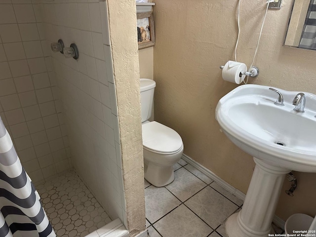 bathroom featuring walk in shower, sink, tile patterned flooring, and toilet