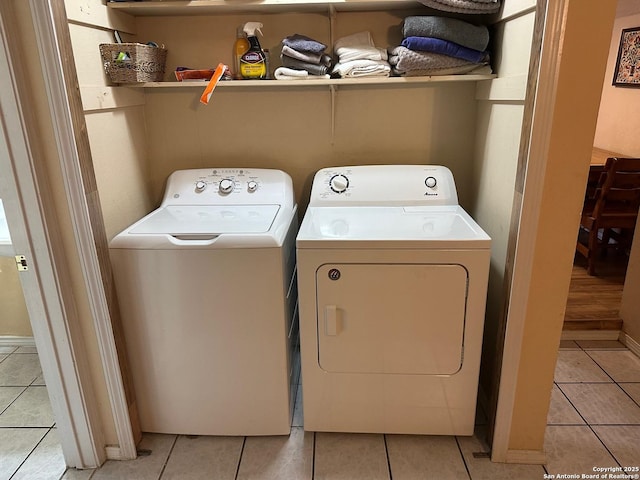 clothes washing area with light tile patterned floors and washing machine and clothes dryer