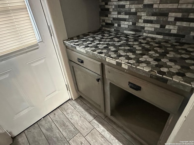 kitchen featuring dark stone countertops, light hardwood / wood-style floors, and tasteful backsplash