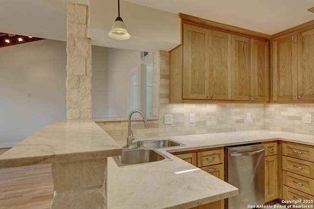 kitchen with stainless steel dishwasher, kitchen peninsula, tasteful backsplash, and sink