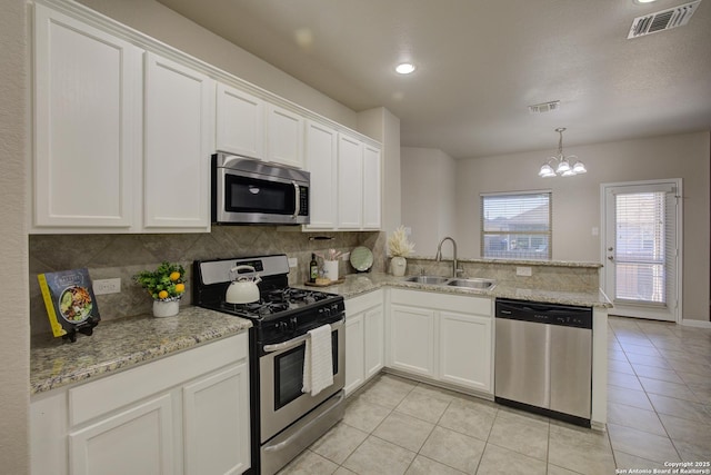 kitchen with appliances with stainless steel finishes, white cabinets, kitchen peninsula, and sink