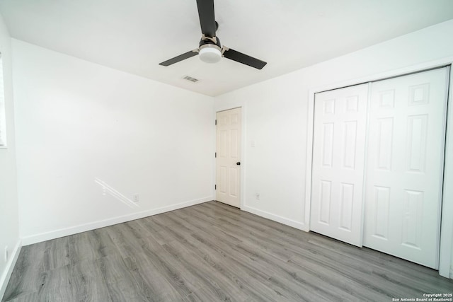 unfurnished bedroom featuring ceiling fan, a closet, and light hardwood / wood-style flooring