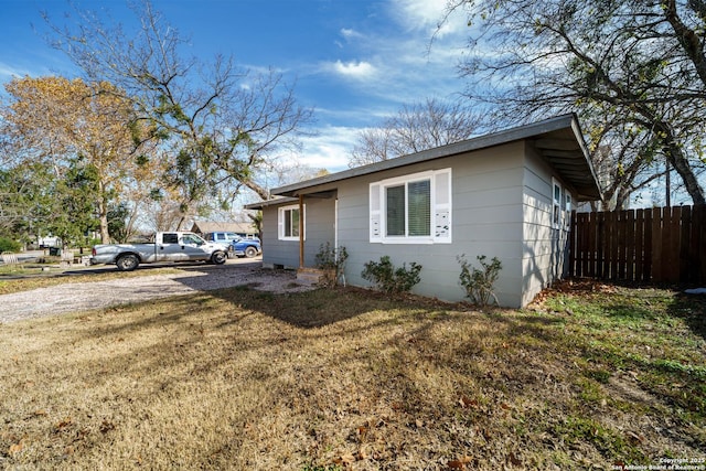 view of side of home with a yard