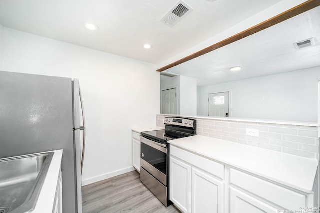 kitchen with backsplash, sink, white cabinetry, light wood-type flooring, and stainless steel appliances