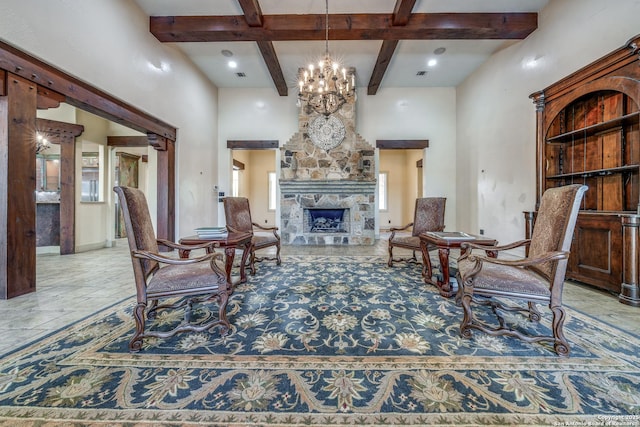 living area featuring beam ceiling, a notable chandelier, a stone fireplace, and a towering ceiling