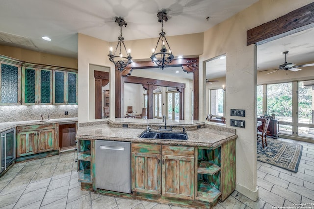 kitchen with ceiling fan with notable chandelier, dishwasher, decorative light fixtures, decorative backsplash, and sink