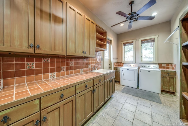 laundry area with cabinets, sink, ceiling fan, and washing machine and dryer