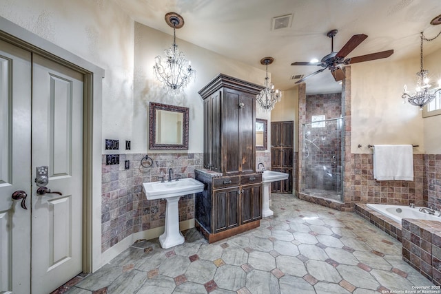 bathroom with ceiling fan, tile walls, and plus walk in shower