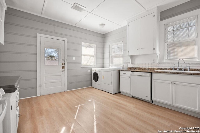 laundry room featuring washing machine and clothes dryer, sink, and light wood-type flooring