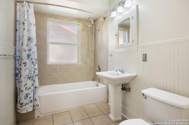 bathroom with tile patterned floors, toilet, and shower / bath combo with shower curtain