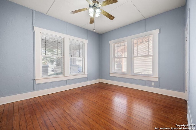 unfurnished room with hardwood / wood-style flooring, ceiling fan, and a wealth of natural light