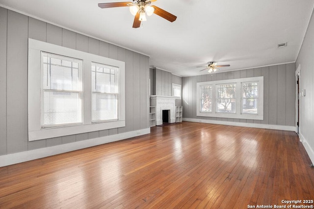 unfurnished living room featuring ceiling fan, hardwood / wood-style floors, and a fireplace