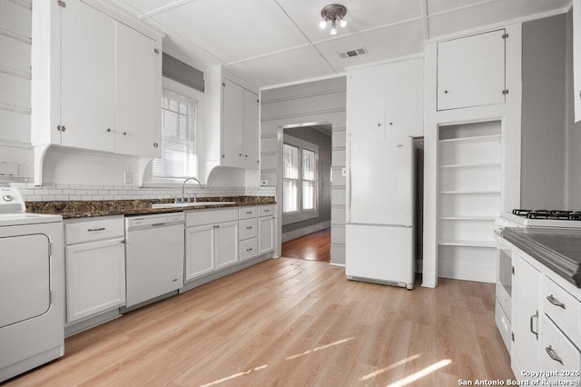 kitchen with washer / dryer, sink, white cabinetry, light wood-type flooring, and white appliances