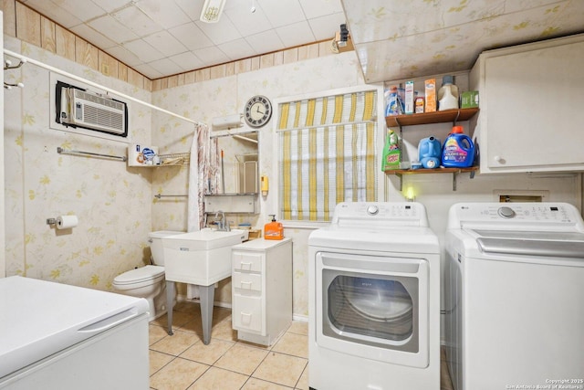 washroom featuring an AC wall unit, light tile patterned flooring, and separate washer and dryer