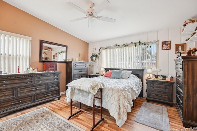 bedroom featuring ceiling fan, light wood-type flooring, and vaulted ceiling