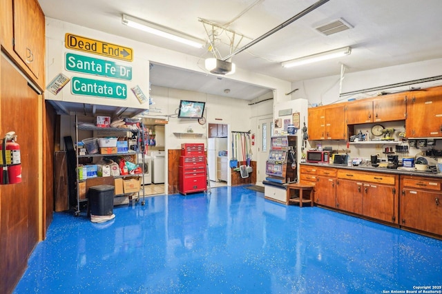 garage featuring a garage door opener and washer / dryer