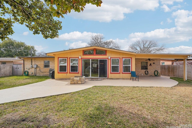 back of property featuring ceiling fan, an outdoor fire pit, a yard, and a patio