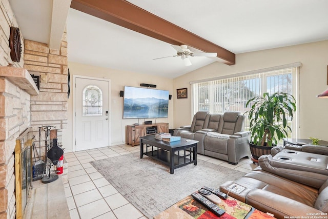 tiled living room featuring ceiling fan, vaulted ceiling with beams, and a stone fireplace