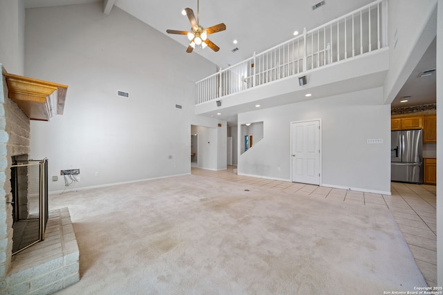 unfurnished living room featuring high vaulted ceiling, beam ceiling, light carpet, and ceiling fan