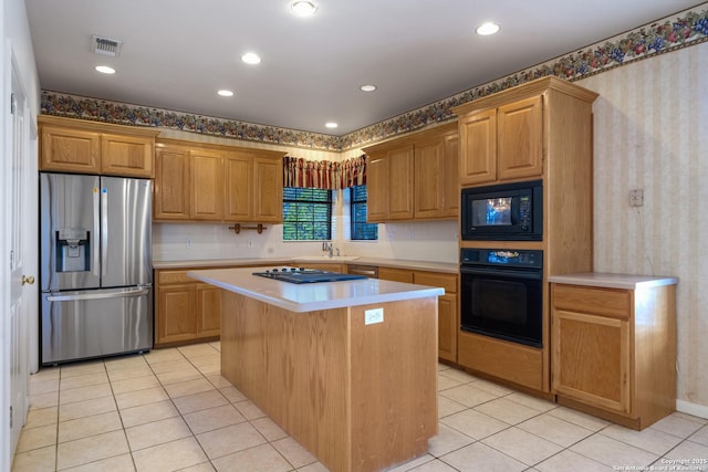 kitchen featuring light tile patterned flooring, black appliances, sink, and a kitchen island