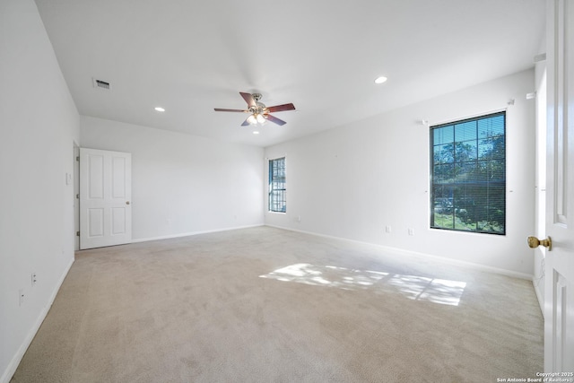 carpeted empty room featuring ceiling fan and a wealth of natural light