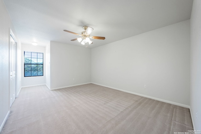 empty room with ceiling fan and light carpet