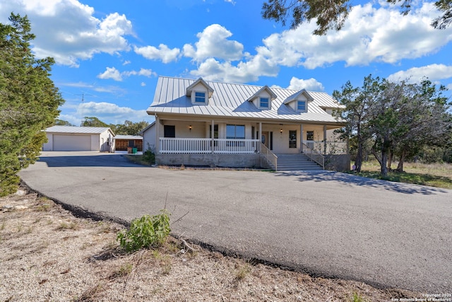 view of front of house with a garage, covered porch, and an outdoor structure