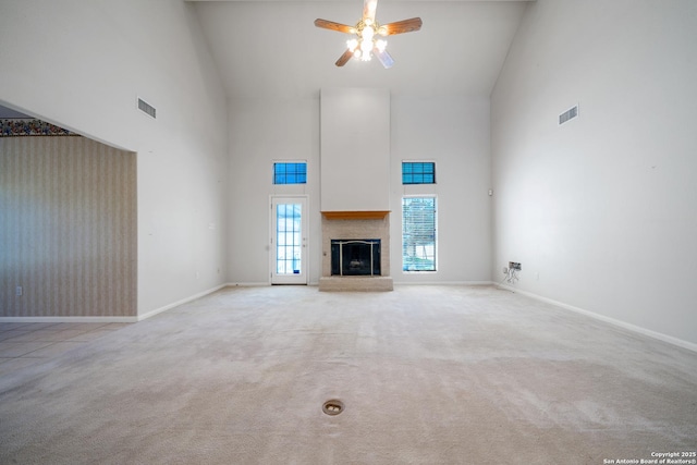 unfurnished living room with high vaulted ceiling, light colored carpet, and ceiling fan