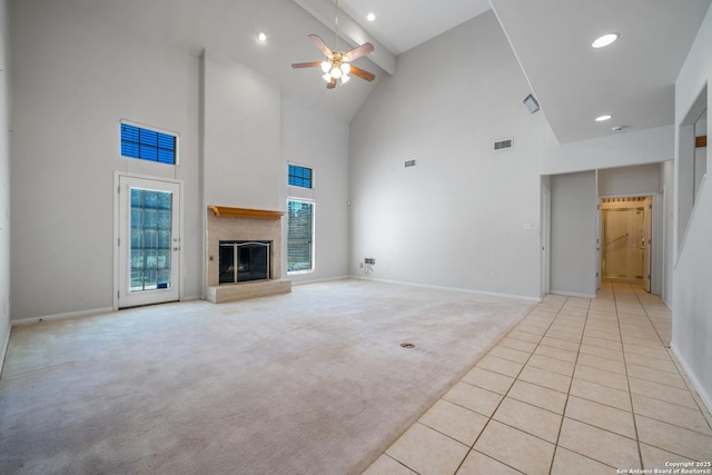 unfurnished living room featuring light carpet, a high ceiling, and ceiling fan