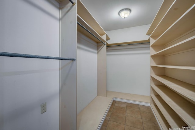 walk in closet with light tile patterned floors