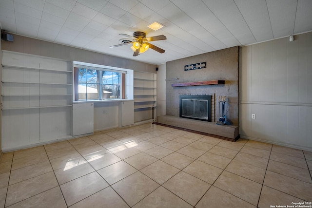 unfurnished living room with ceiling fan, light tile patterned floors, and a fireplace