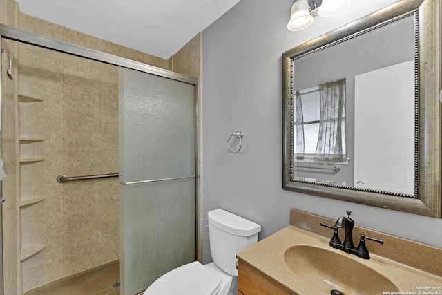 bathroom featuring toilet, a shower with door, and vanity