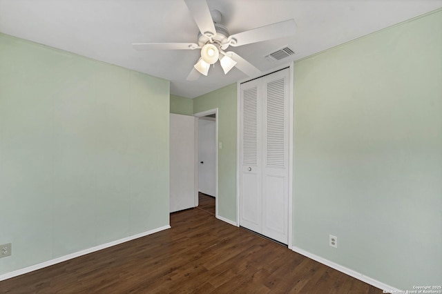 unfurnished bedroom featuring ceiling fan, dark hardwood / wood-style flooring, and a closet